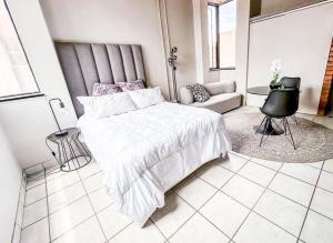 a bedroom with a large bed and a couch at Tulisa Park in Johannesburg