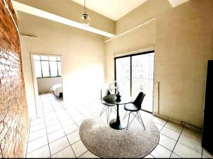 a room with a table and chairs and a bedroom at Tulisa Park in Johannesburg