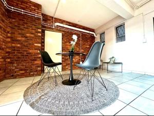 a table and chairs in a room with a brick wall at Tulisa Park in Johannesburg