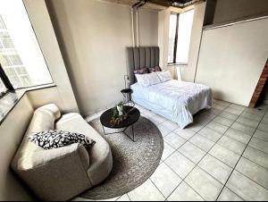 a living room with a couch and a bed at Tulisa Park in Johannesburg
