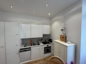 a kitchen with white cabinets and a sink at Apartment in Historic Villa in Faido +12 photos
