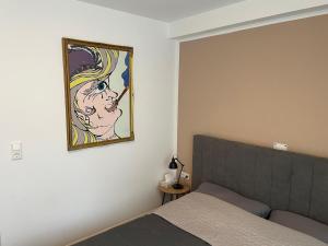 a bedroom with a bed and a painting on the wall at Innside - Terrace and Mountain Views in Innsbruck