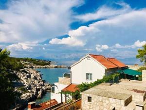a white house with a view of the water at Roso Seafront House in Selca kod Bogomolja