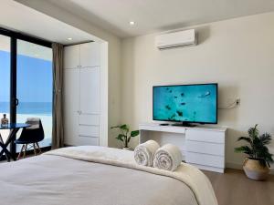 a bedroom with a large bed with a flat screen tv at Little Pearl Sea View Studio in San Antonio del Mar