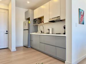 a kitchen with white cabinets and a refrigerator at Little Pearl Sea View Studio in San Antonio del Mar +12 photos