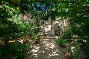 a garden with trees and plants and a building at Hotel Dubrava in Budva