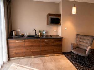 a kitchen with a sink and a chair at Villa Malibu in Zegrze Południowe
