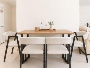 a dining room table with white chairs around it at Panorama View in Kalamata
