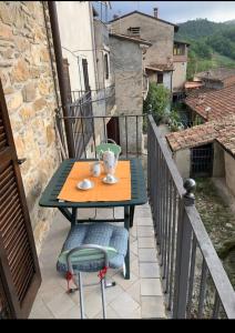 a table and chairs on the balcony of a house at La casa dei Nonni in Romagnese