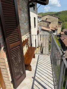 a door to a balcony with a wooden bench at La casa dei Nonni in Romagnese