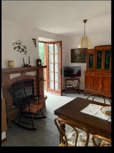 a living room with a fireplace and a table and chairs at La casa dei Nonni in Romagnese