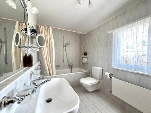 a bathroom with a sink and a toilet and a tub at Chalet Le Nid D'argent - Dans la nature in Crans-Montana +58 photos