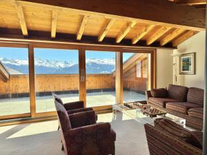 a living room with a view of mountains at Chalet Le Nid D'argent - Dans la nature in Crans-Montana