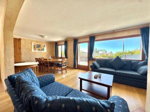a living room with a blue couch and a table at Chalet Le Nid D'argent - Dans la nature in Crans-Montana