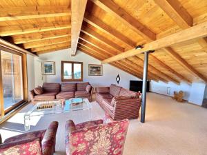 a living room with couches and a table at Chalet Le Nid D'argent - Dans la nature in Crans-Montana