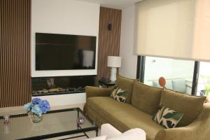 a living room with a couch and a flat screen tv at Casa Rural La Tajuela in Bohonal de Ibor