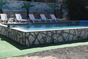 a swimming pool with lounge chairs and a poolificialificialificialificialificialificialificial at Salo Pool Hotel by the Sea in Gonio