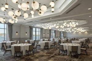 a banquet room with white tables and chairs and chandeliers at Halifax Marriott Harbourfront Hotel in Halifax