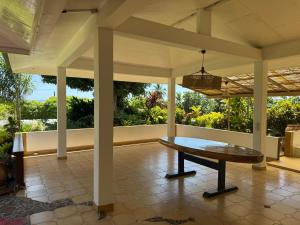 a screened porch with a table on a patio at Hiro'a - Fare Orotia in Taputapuapea