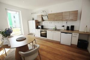 a kitchen with white cabinets and a wooden floor at Jessop Haus in Lübeck +72 photos