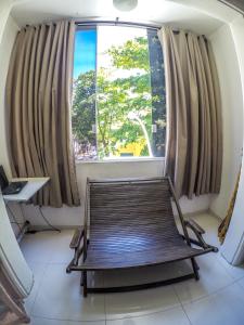 a bench in front of a large window at Baixo Copa Guest House in Rio de Janeiro