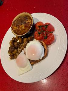 a plate of food with eggs and tomatoes on a table at Ramadale Stornoway in Stornoway