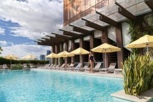 a woman walking by a swimming pool at a hotel at The Westin Perth in Perth