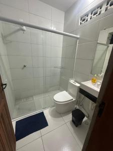 a bathroom with a shower and a toilet and a sink at Cantinho da Beth in Caravelas