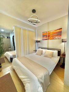 a bedroom with a large white bed and a bathroom at Entire House with Parking, Full Kitchen and Near SRP, Seaside and Nustar in Talisay