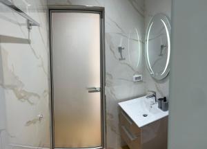 a bathroom with a shower and a sink and a mirror at Irene's rooms in Himare +81 photos