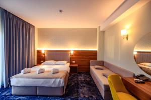 a hotel room with two beds and a couch at Hotel Ryon Mamaia-Nord in Mamaia Sat/Năvodari
