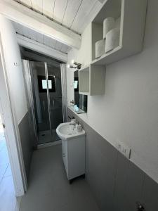 a white bathroom with a sink and a shower at Green House La Torre in Avola +17 photos