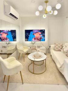 a living room with a white couch and a table at Entire House with Parking, Full Kitchen and Near SRP, Seaside and Nustar in Talisay