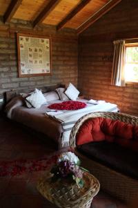two beds in a room with two chairs and flowers at Cabañas La Tierra Grande in Zacatlán