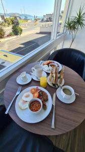 ein Tisch mit Frühstücksessen auf einem Tisch mit Blick auf den Strand in der Unterkunft The Torland Hotel - Paignton Seafront, Guaranteed free parking in Paignton + 63 Fotos