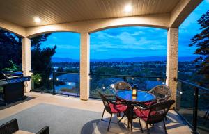 a patio with a table and chairs on a balcony at Sunrise Valley Suite in West Kelowna