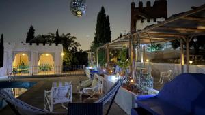 a patio with chairs and a glass house at night at Torre Calera in Arganda del Rey