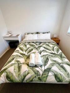 a bedroom with a bed with two towels on it at Room and Private Bathroom in Woodend in Woodend