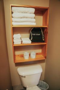 ein Badezimmer mit Toilette und Handtüchern auf einem Regal in der Unterkunft Lenroot Lodge in Seeley
