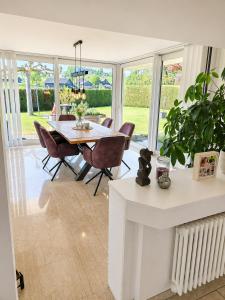 a dining room with a table and chairs at Stylish house with garden, sauna & pool in Mörschwil