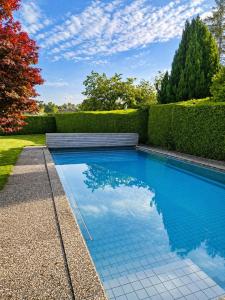 a swimming pool in the middle of a yard at Stylish house with garden, sauna & pool in Mörschwil