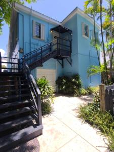 a blue house with stairs in front of it at Duval Street Suite w kitchen and shared heated pool in Key West +13 photos