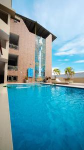 a large blue swimming pool in front of a building at Hotel Nilas in Tarapoto