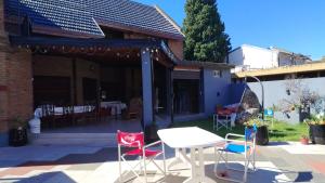 a table and chairs in front of a house at La Casa de Miel in Villa Ballester