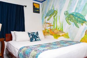 a bedroom with a bed and a mural of turtles at Olas Permanentes El Zonte in El Zonte +180 photos
