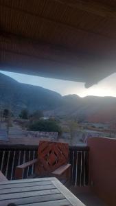 a view of the mountains from a porch with a bench at Tinkunaco in Purmamarca +1 photo