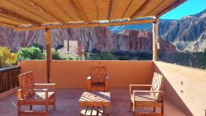 a porch with chairs and tables and a view of mountains at Tinkunaco in Purmamarca
