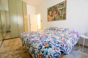 a bedroom with a bed with a floral comforter at B&B Casalecchio Appartamento privato in Casalecchio di Reno