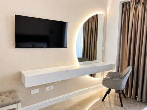 a living room with a television on a wall at Lungolago Apartment Ohrid in Ohrid