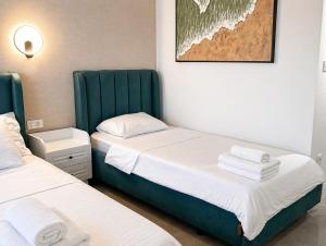 two beds in a small room with green accents at Lungolago Apartment Ohrid in Ohrid +9 photos